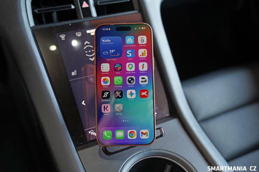 Telefon upevněný v interiéru auta Telefon na držáku před středovou konzolou automobilu
